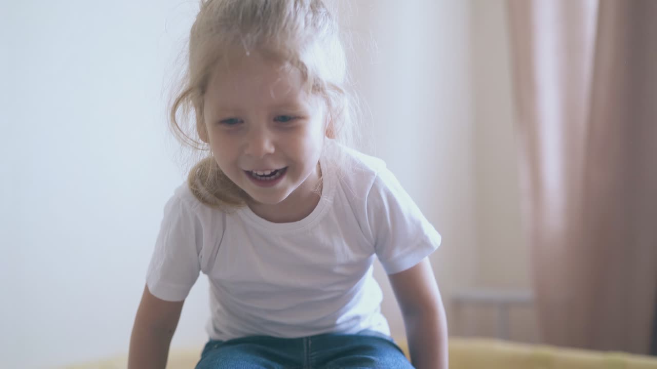 kleines mädchen in t-shirt springt in der spielhalle im kinderzimmer