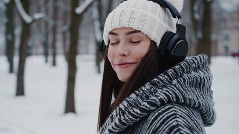 young woman enjoying music in winter with headphones