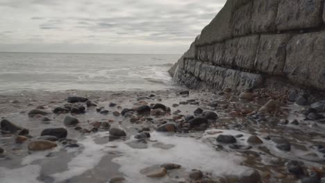 cerrar vista de pequeñas olas rompiendo en la playa de la ciudad de brighton, inglaterra