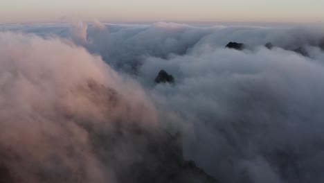 aerial shot in the morning showing fast moving clouds passing by over mountains, madeira