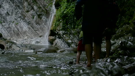 personas caminando a través de un arroyo de cascada