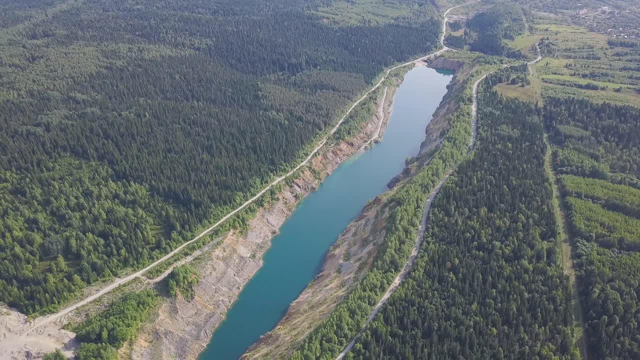 vista aérea de un lago de cantera rodeado de bosque