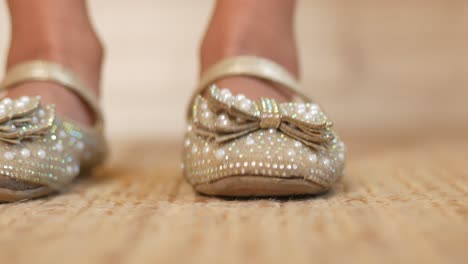 close-up of a child's decorated gold shoes