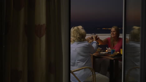 People-dining-and-drinking-wine-on-balcony