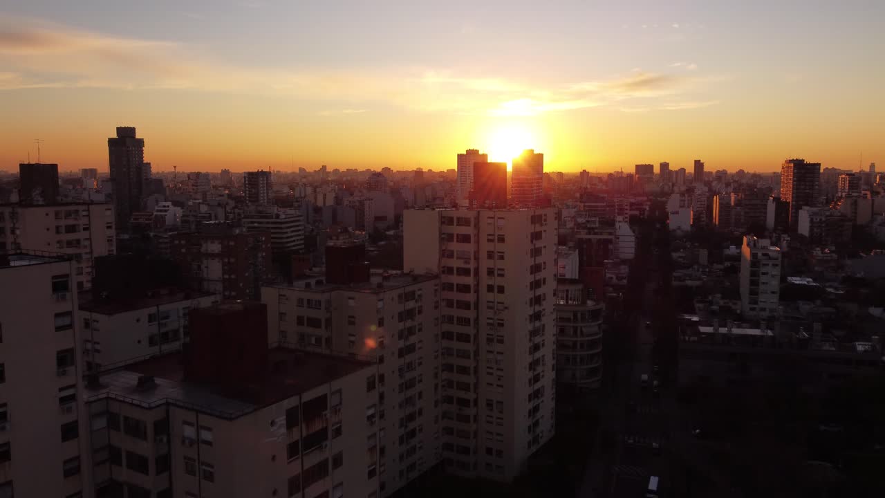 silueta de bloques de apartamentos de gran altura en buenos aires durante la puesta de sol dorada, 4k - vuelo aéreo ascendente hacia el cielo iluminado