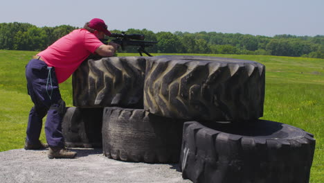 tractor tires at shooting range with marksman steadying aim in precision rifle match