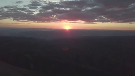 mt nebo utah at sunrise sunset beautiful sun flare over the mountain range - aerial tilt