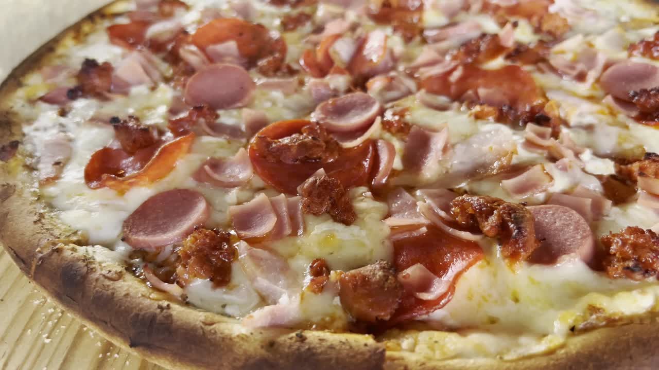 Close-up of a freshly baked pizza topped with pepperoni, sausage, and melted cheese
