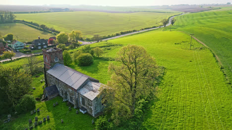 drone imagery reveals burwell village, history as medieval market town—surrounded by countryside fields, vintage red brick houses, and the abandoned saint michael parish church on lincolnshire's wolds