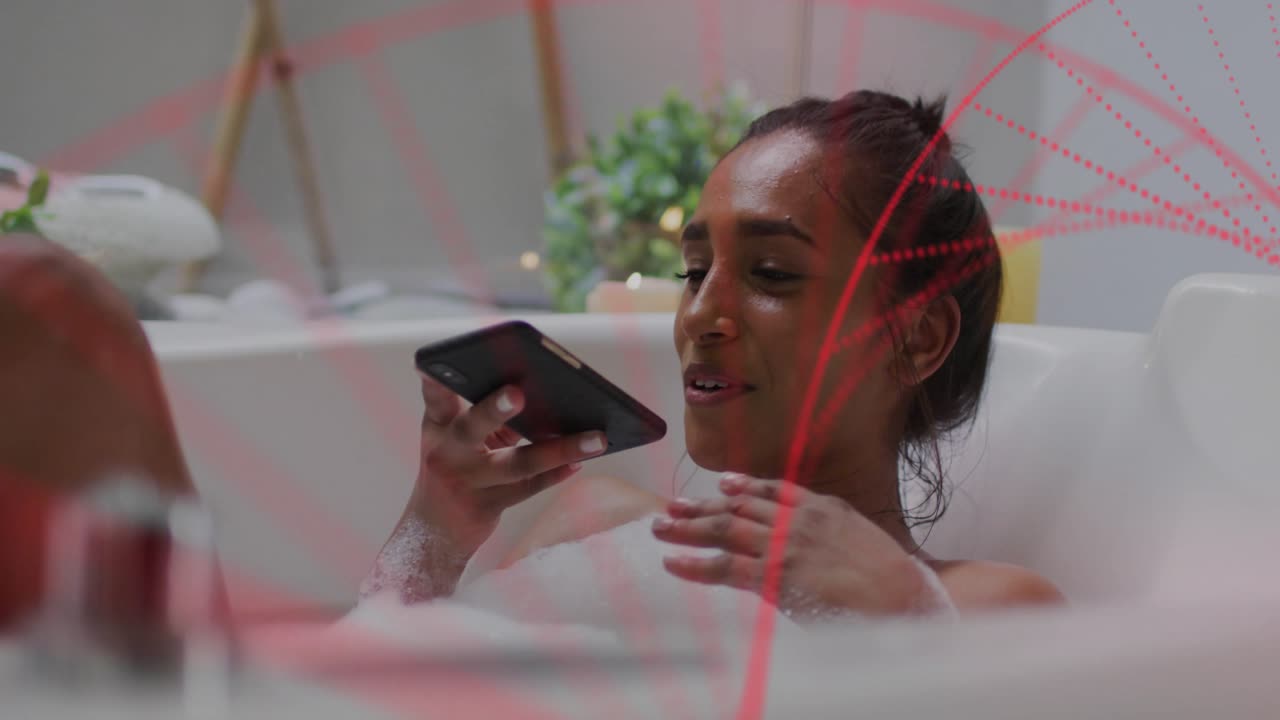 Woman speaking into phone in tub, starting call, activating red arcs over her, serving tech demo