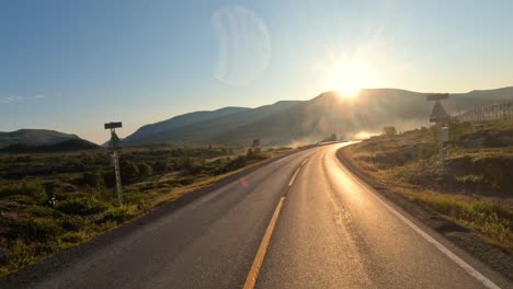 Conduciendo-Un-Coche-Por-Una-Carretera-De-Noruega-Al-Amanecer.