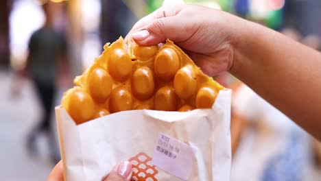 hands holding and eating bubble waffles