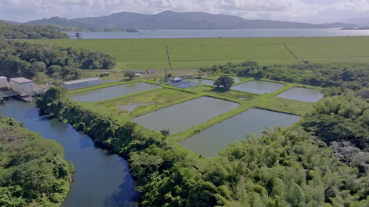 Aerial View Of Fish Hatchery Ponds And Agricultural Fields On Riverbank.