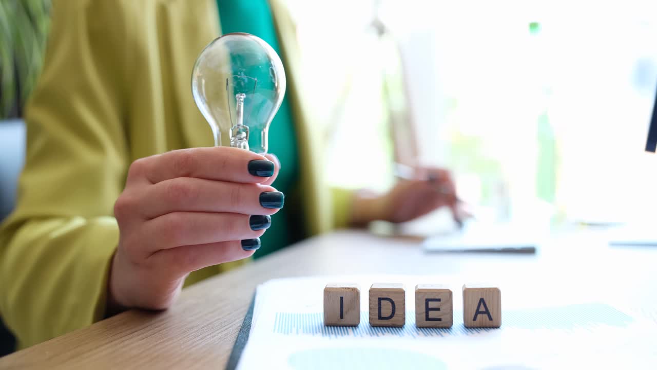 Idea di testo su cubi e imprenditore che tiene una lampadina