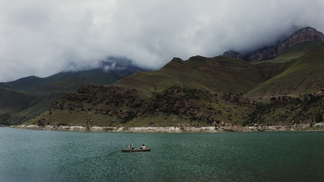 산의 호수 에서 카누 를 타는 사람 들