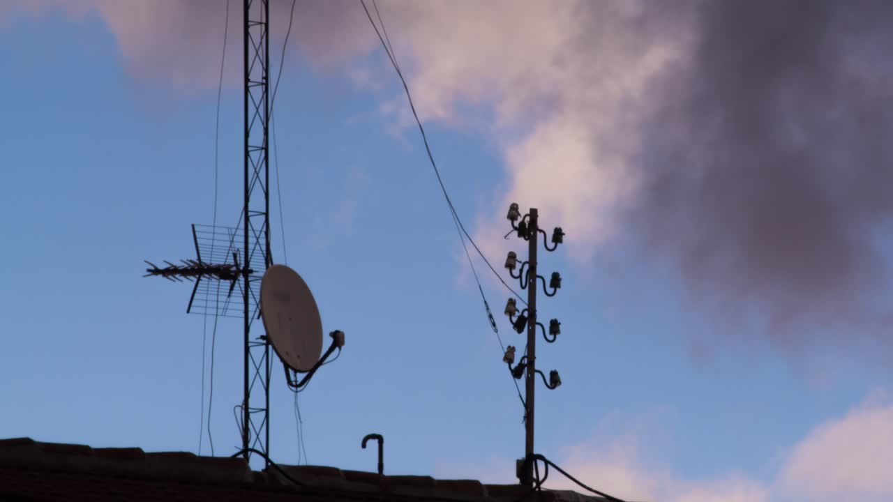 Timelapse af skyer, der bevæger sig over tagantenner og parabolantenne