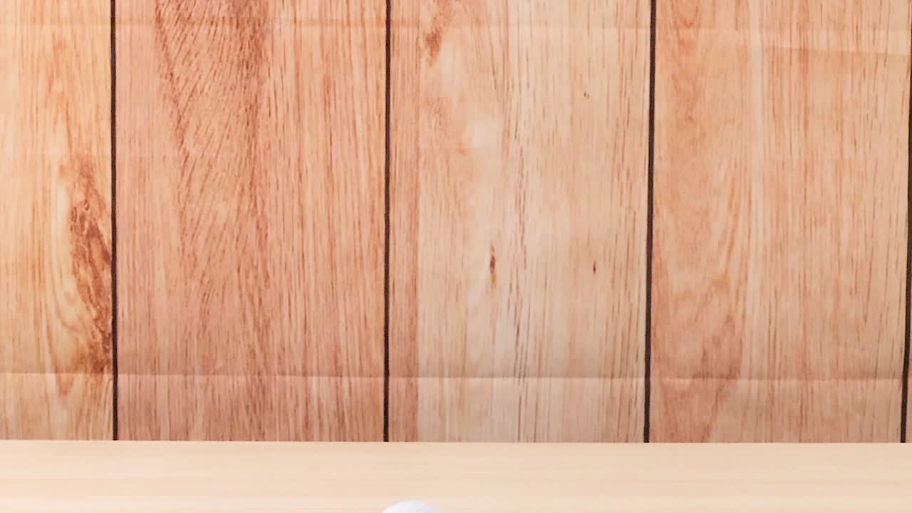 골프 공이 나무 바닥을 가로질러 움직인다