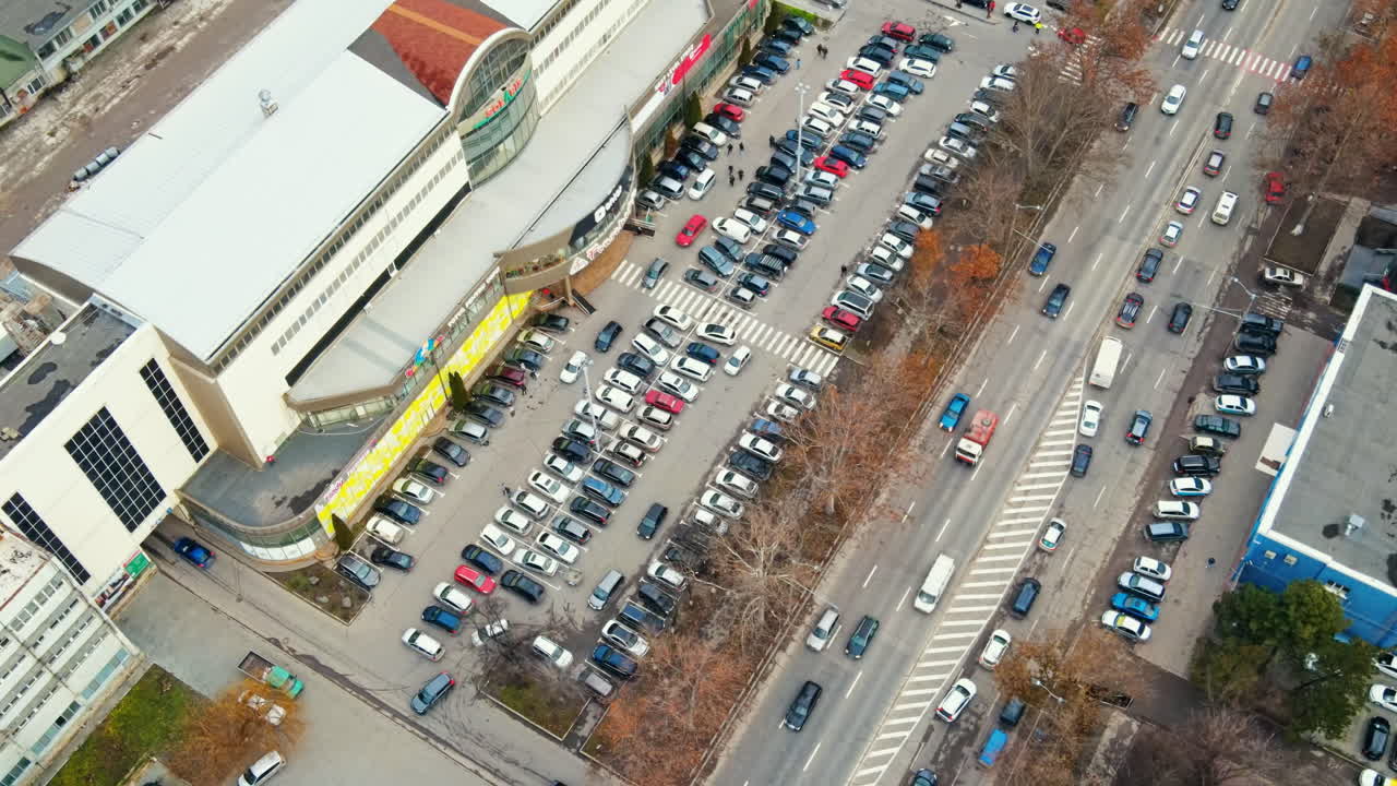 Aerial drone view of Chisinau. View of a street road with moving cars, parking and bare trees along it. Moldova