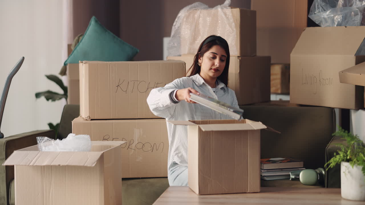 Woman packing cardboard boxes for moving