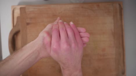 zenithal shot of a person stuffing chocolate inside a coconut rock bun then rolling it