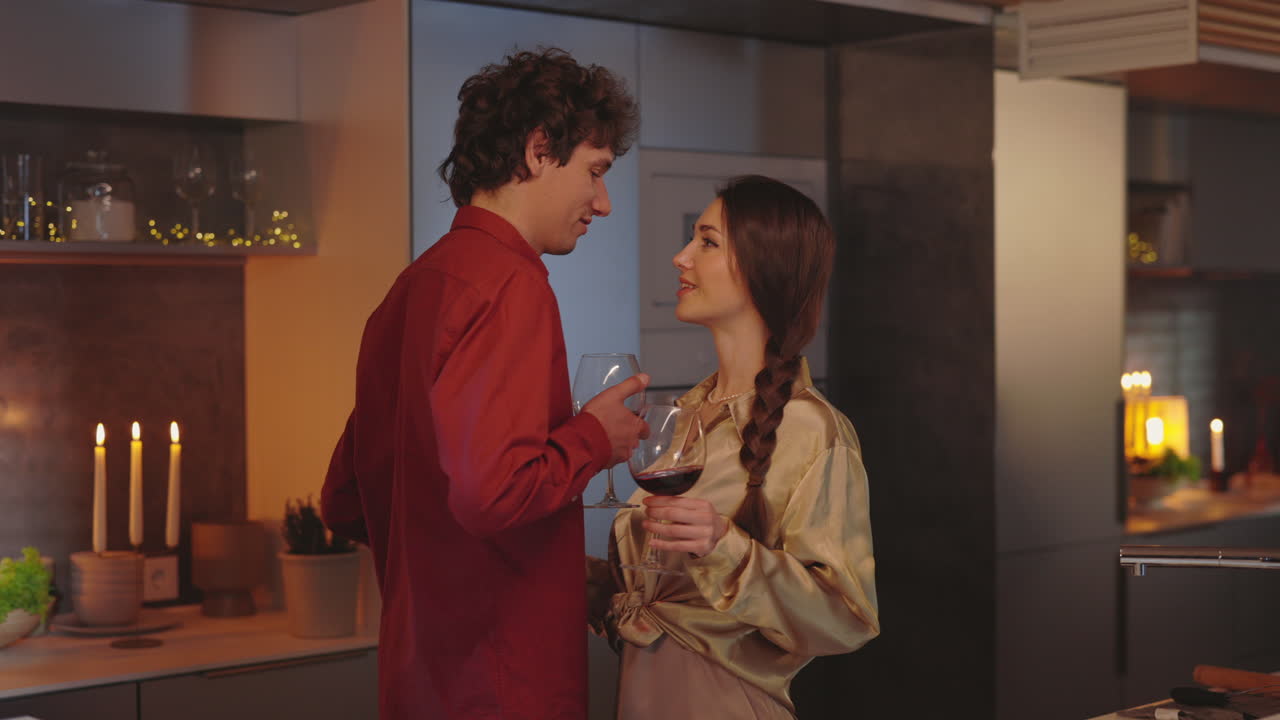 Couple enjoying a romantic evening with wine and conversation in their kitchen
