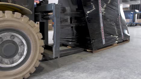 Solar-panel-crate-about-to-be-lifted-by-forklift-at-solar-warehouse,-Handheld-dolly-right-shot