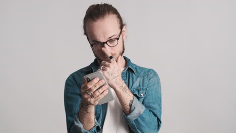 caucasian young man using smartphone on camera.