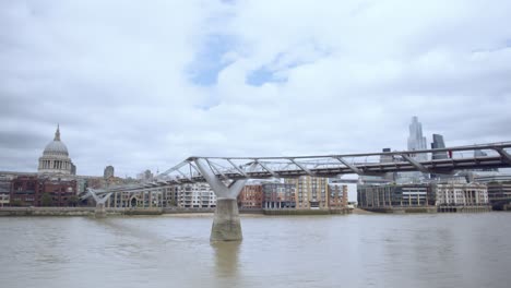 london thames millennium bridge with st paul's cathedral in the background people moving and clouds moving in time-lapse