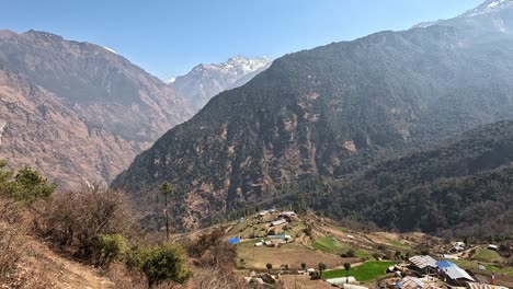 vista sobre un valle montañoso con altas laderas del himalaya y una terraza rural aldea agrícola