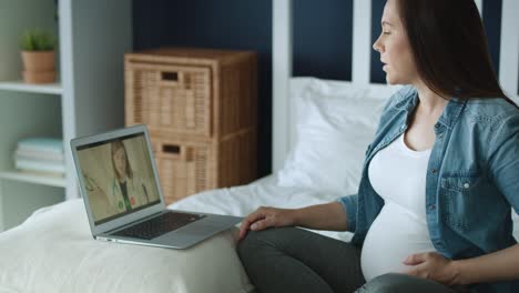 Tracking-left-video-of-pregnant-woman-talking-with-doctor-online.