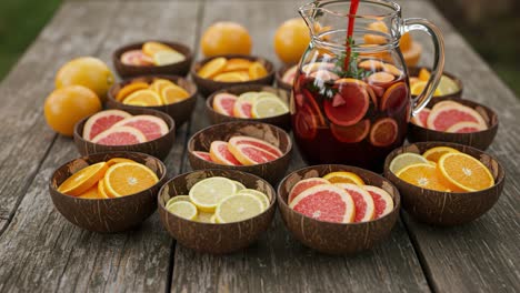 a vibrant display of fresh citrus fruits and refreshing beverage: a beautiful picnic setting with colorful bowls of orange, lemon, and grapefruit slices on a rustic wooden table