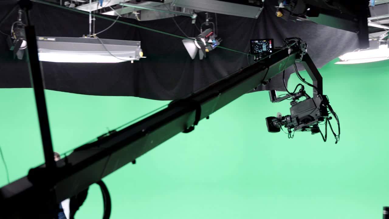 equipo de filmación en el estudio verde de rodaje de video. croma - tecnología de combinar dos o más imágenes o cuadros en una sola composición. camarógrafo, director, equipo. industria cinematográfica.