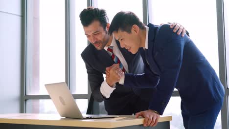 two happy business people celebrate at office