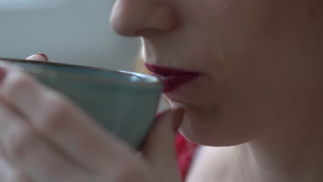 cerca de dama con pintalabios bebiendo café de una hermosa taza azul