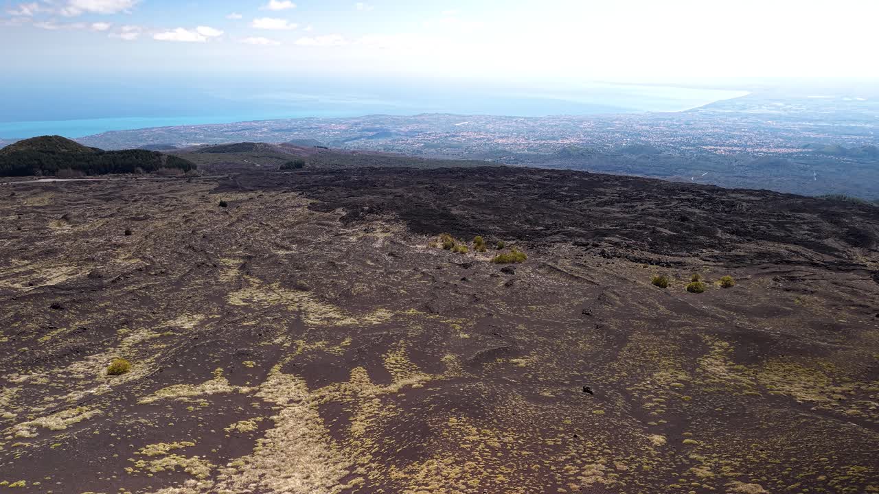 Ampla paisagem aérea de um planalto vulcânico árido perto das crateras Silvestri sob um céu nublado, Sicília, Itália
