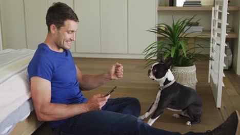 Caucasian-man-is-playing-with-his-dog-at-home