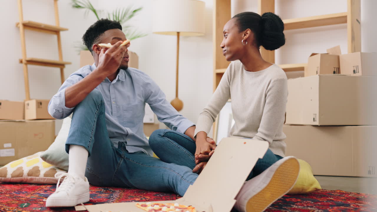 Black couple eating pizza in new house