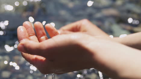 Nahaufnahme-Der-Hände-Einer-Frau,-Die-An-Einem-Sonnigen-Tag-In-Einem-Klaren-Fluss-Gewaschen-Wird