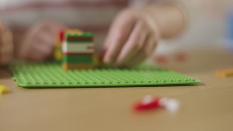 Nahaufnahme-Von-Zwei-Kindern,-Die-Zu-Hause-Mit-Plastikbausteinen-Auf-Dem-Tisch-Spielen-5