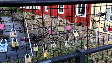 love locks on a brige fence with a dryed out stone canal, and old buildings on each side in the background