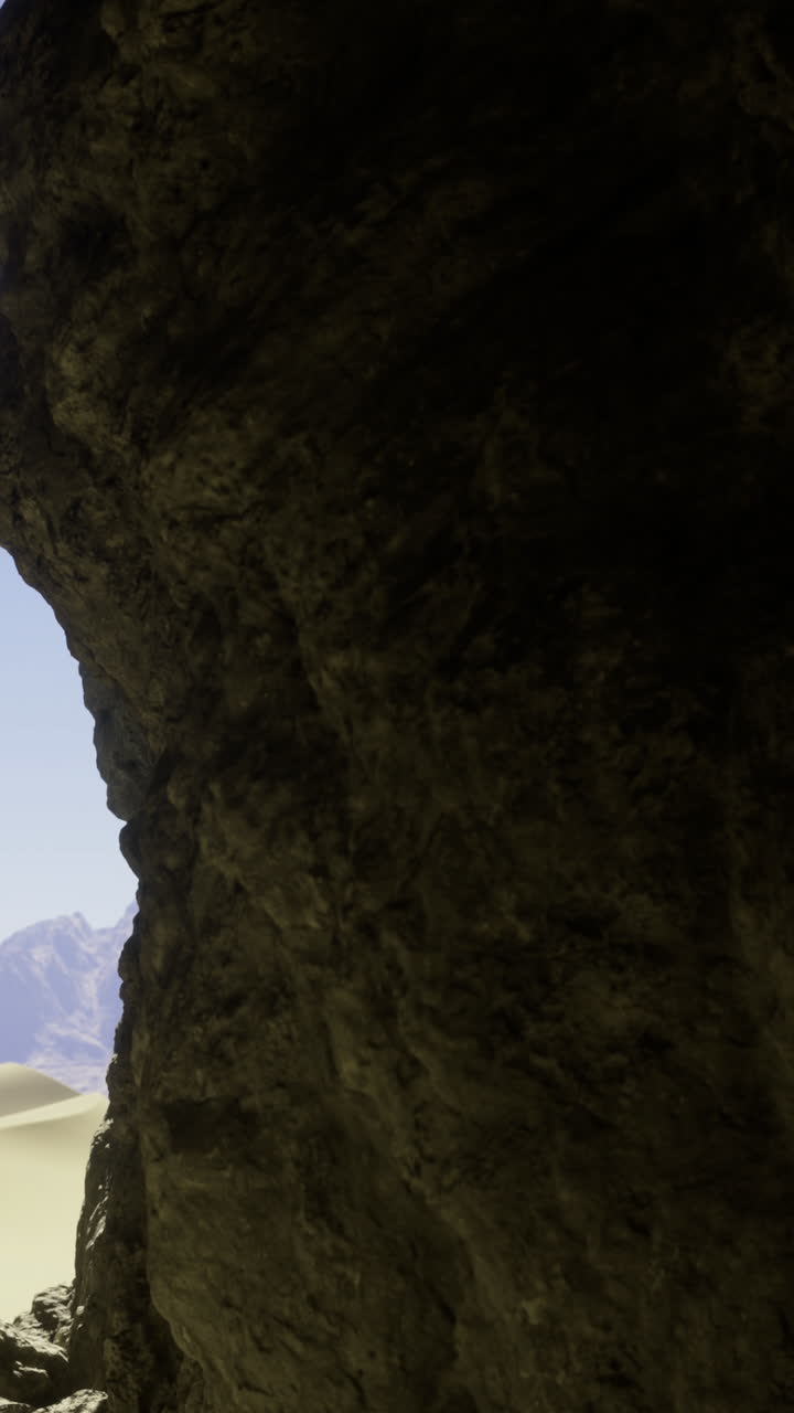 Vista da una grotta attraverso un'apertura ai margini di un paesaggio desertico