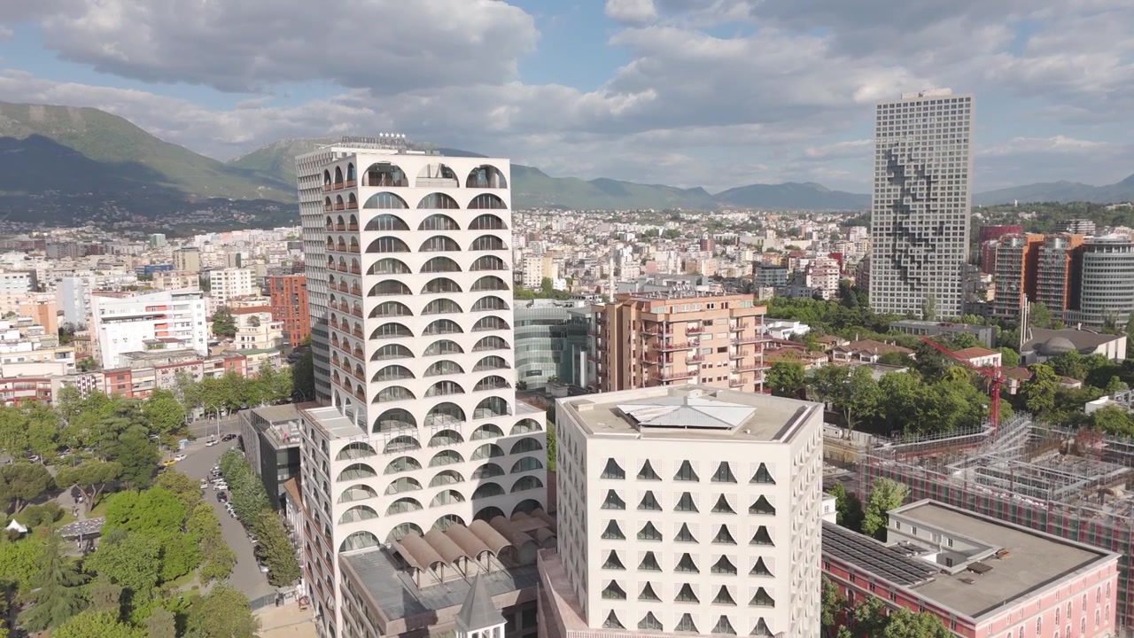 Vista aerea - Centro città di Tirana, Albania, con moderni grattacieli, torre dell'orologio e sfondo montuoso