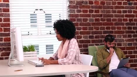 Casual-businesswoman-working-at-her-desk