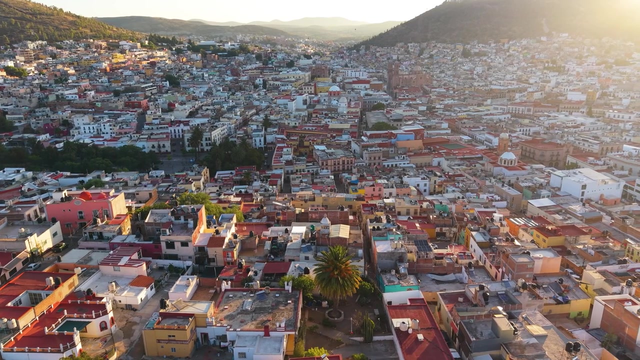 Una vista aerea immersiva e ad alta quota che cattura il vibrante e denso tessuto urbano coloniale all'interno della drammatica valle montana di Guanajuato