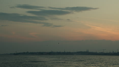 Silueta-De-La-Ciudad-Al-Atardecer-Con-Gaviotas-Y-Mar-En-Calma-En-Helsinki,-Finlandia-En-Un-Cálido-Día-De-Verano