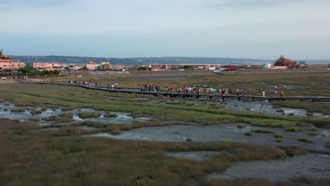 Cinematic-circular-pan-shot-capturing-the-historic-lighthouse-and-beautiful-tidal-flats-at-Gaomei-wetlands-preservation-area-at-sunset,-Taichung,-Taiwan