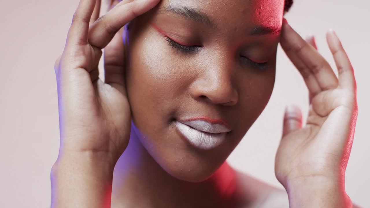 Femme afro-américaine aux cheveux courts foncés sous une lumière bleue et rose, au ralenti