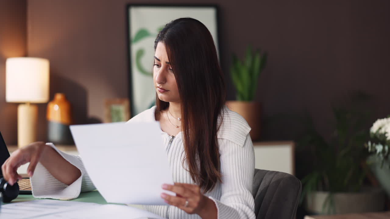 Worried woman reviewing paperwork at home