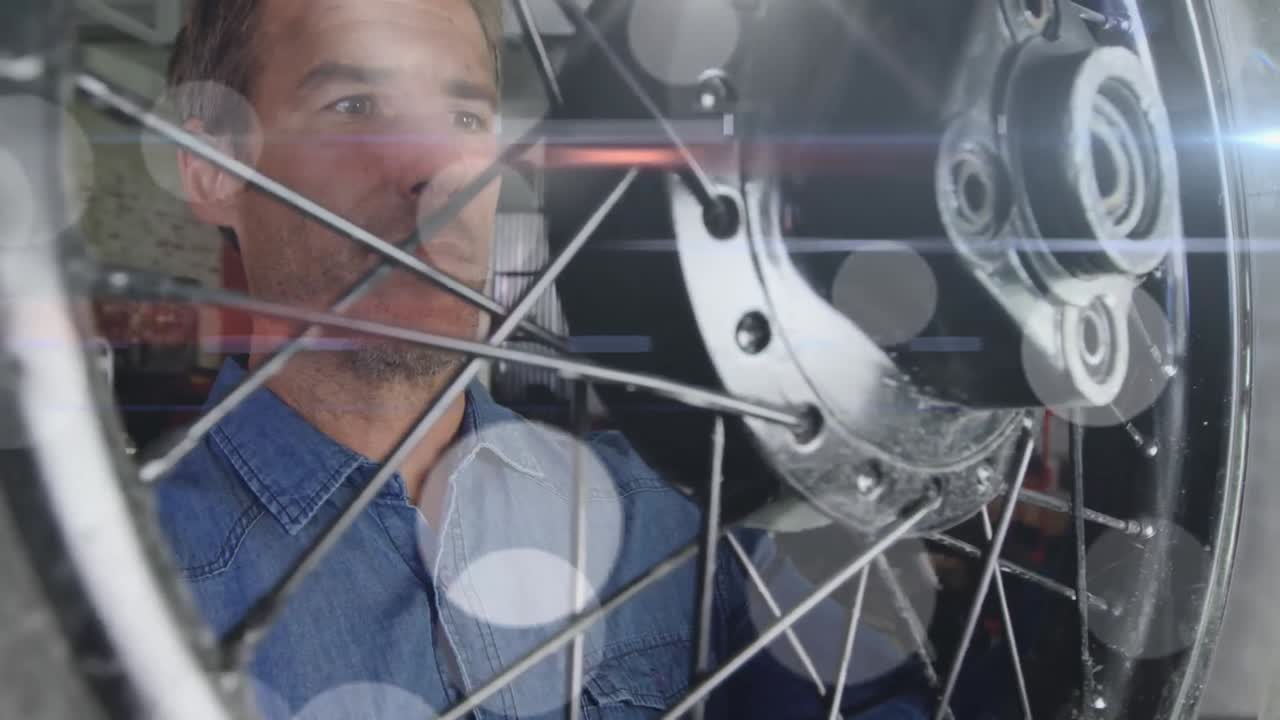 차고에서 오토바이를 수리하는 백인 남성 메카닉 위에 반 ⁇ 이는 불빛의 애니메이션