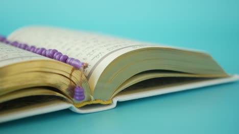 open quran with prayer beads